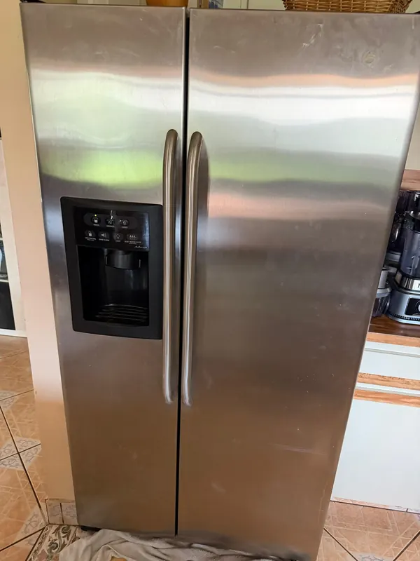 Stainless steel side-by-side refrigerator with an ice and water dispenser in a kitchen